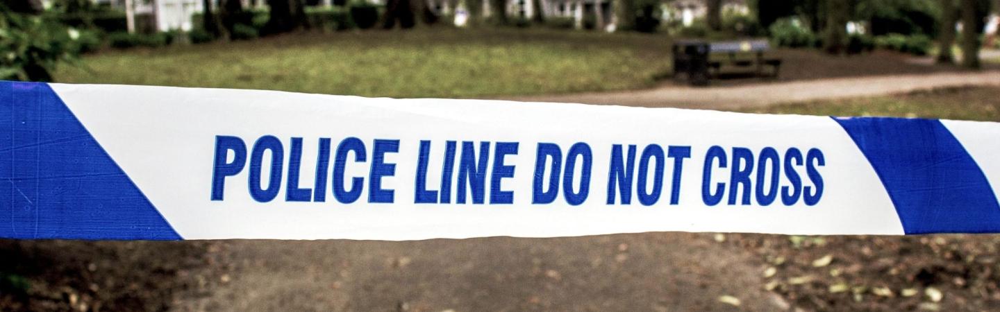 Image shows a park with police tape